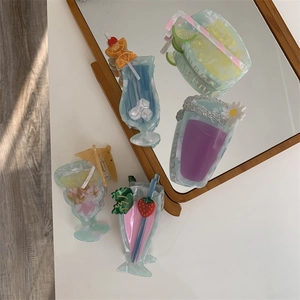 Detailed view of four colorful cocktail drink shaped acetate hair clips in a mirror