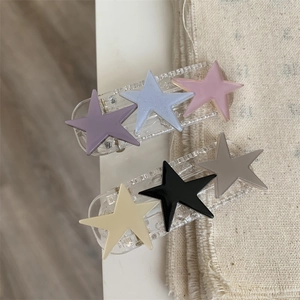 Detailed close-up of acrylic star hair clips in pastel and neutral color palettes