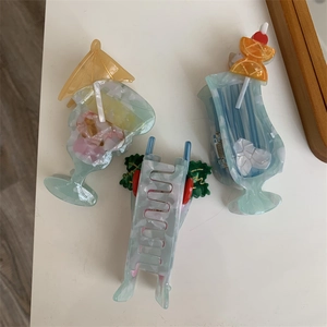 Detail view of acetate cocktail glass hair clips with summer umbrella and fruit decorations