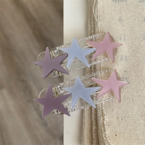 Detail shot of two-piece star hair clips in pastel resin with subtle glitter finish