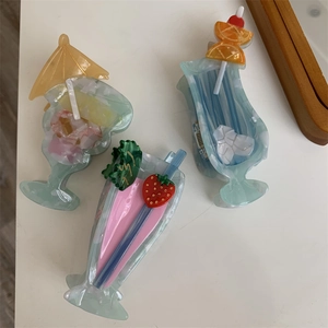 Detailed macro view of three cocktail-shaped acetate hair claws with summer drink designs