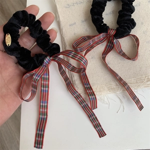 Elegant black velvet hair scrunchie with a red plaid ribbon bow and golden metal charm