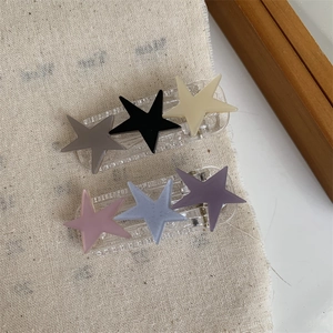 Detail view of star-shaped hair clips in matte finish with a mix of aesthetic colors