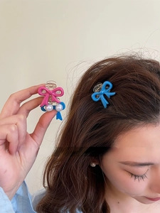 Detail of pink and blue bow hair claws with pearl accents and clear base grips