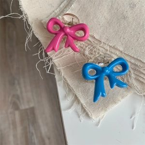 Detail view of cute bow-shaped hair clips in pink and blue resin on linen background