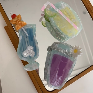Detailed close-up of three creative cocktail-shaped hair claws with marble textures