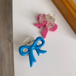 Close-up of cute pink and blue bow hair clips with transparent acrylic claw design