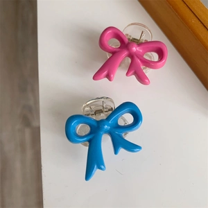 Detailed top view of pink and blue mini bow hair clips with transparent base