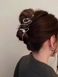 Silver metallic curved hair claw clip with white pearl detail on female model's hairstyle