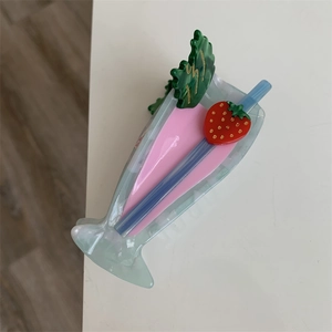Detail showing creative strawberry milkshake cocktail hair claw clip made of acetate