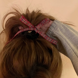 Elegant red plaid bow hair scrunchie for women tied in a high ponytail hairstyle