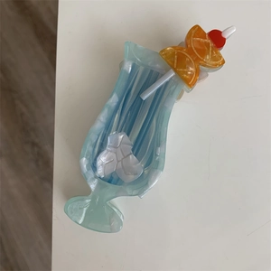 Detail of creative cocktail hair claw clip with lemon and cherry accents in light blue