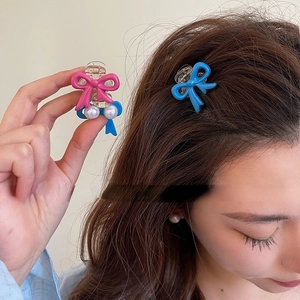 Cute pink and blue bow hair clips with pearls for a high skull top hairstyle look