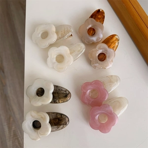 Gros plan de barrettes à fleurs en acétate aux couleurs marbrées assorties