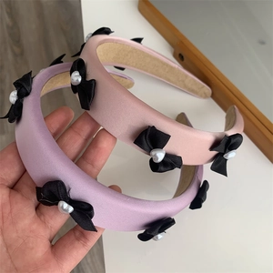 Satin padded headbands in purple and pink with black bows and heart pearl accents