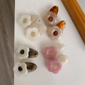 Détail de huit mini pinces à cheveux en acétate en forme de fleurs aux motifs marbrés variés