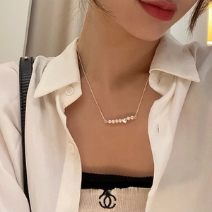 Primo piano dell'elegante collana di perle d'acqua dolce con ciondolo a cuore su modella