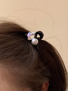 Dettaglio del fermaglio per capelli con cuore di cristallo e perle su capelli castani