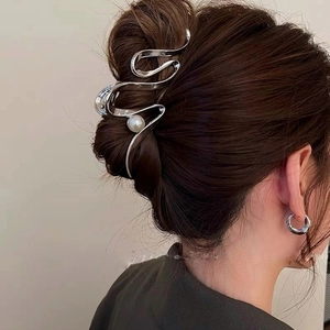 Silver wavy metal hair claw clip with pearl accent on model for thick hair styling