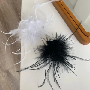 Gros plan détaillé de pinces à cheveux en plumes noires et blanches avec petites perles
