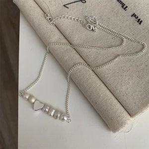 Dettaglio macro del ciondolo a cuore in argento con perle d'acqua dolce e moschettone