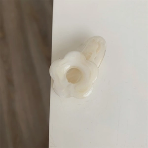 Détail d'une pince à cheveux fleur blanc crème en résine avec texture marbrée