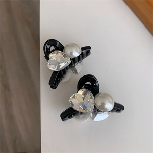 Dettaglio delle mini mollette per capelli con cuore di cristallo e perle eleganti