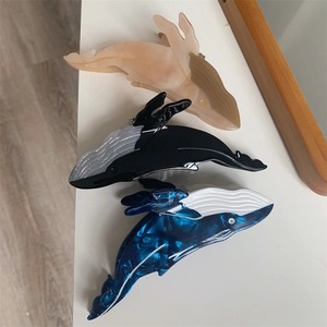 Three acetate hair clips in blue whale shape featuring marble texture and sleek finish