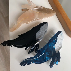 Set of three creative whale-shaped acetate hair claws in pink, black, and blue marble