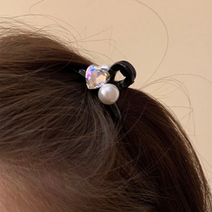 Mini molletta per capelli con cristallo a cuore e perle bianche su capelli scuri