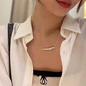 Elegante collana con pendente a cuore di perle d'acqua dolce e catena d'oro su modella