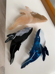 Detailed set of whale-shaped hair claws in blue marble, black and nude acetate finishes