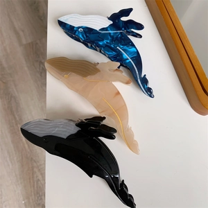 Whale shaped acetate hair claws in blue marble and beige patterns for women