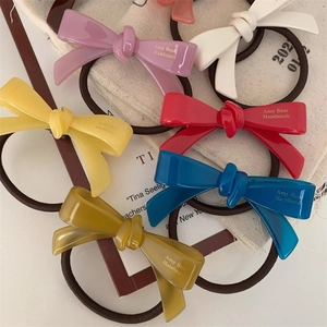 Détail d'élastiques à cheveux en acétate coloré avec inscription dorée Amy Bear Handmade
