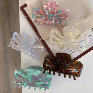 Detailed close-up of 5-piece acetic acid hair claw clips in assorted marble textures
