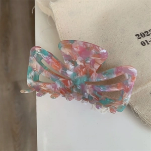 Close-up of pink marble acetate hair claw with hollow texture and handmade engraving