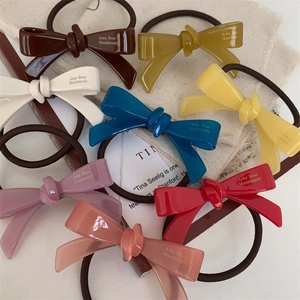 Détails d'élastiques à cheveux avec nœud fait main en plusieurs couleurs sur tissu