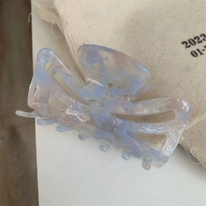 Detailed macro view of the handmade acetate hair claw with pink marble texture