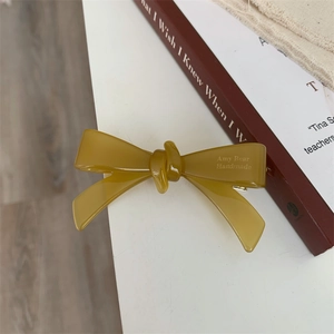 Détail d'une pince à cheveux en acétate ambré faite à la main avec un nœud élégant