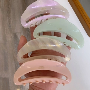 Detailed set of four moon-shaped acetate hair claws in pastel colors with gold lettering