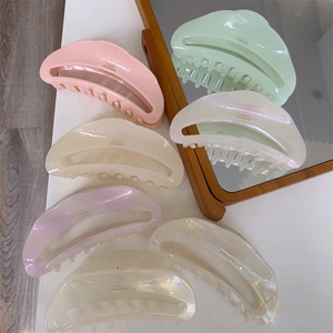 Detailed view of crescent acetate hair claws with a pearlescent finish in pastel colors