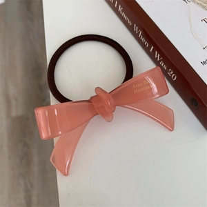 Détail d'un élastique à cheveux en acétate rose avec lettrage doré Amy Bear