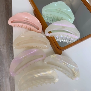 Macro display of pastel crescent acetate hair claws featuring the France Handmade logo