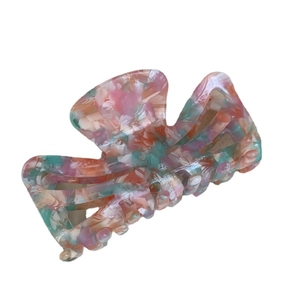 Pink marbled acetate hair claw clip with cutout texture and hollow shark jaw design