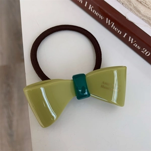 Detail of olive green acetate bow hair tie with handmade lettering and high-elastic band