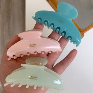 Détail de trois grandes pinces à cheveux pastel avec lettrage doré Barrette la France