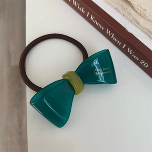 Close-up of handmade dark green acetate bow hair tie with Amy Bear lettering