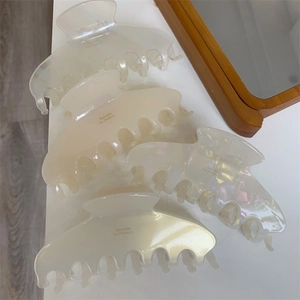 Macro detail of large acetate hair claws with pearlescent finish and French lettering