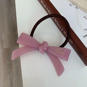 Élastique à cheveux avec nœud en acétate rose et lettrage doré sur fond esthétique