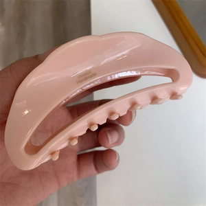 Detail showing peach pink acetate crescent hair claw with France Handmade lettering